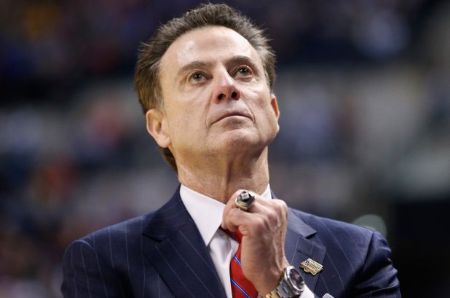 Rick Pitino in a black suit poses for a picture.